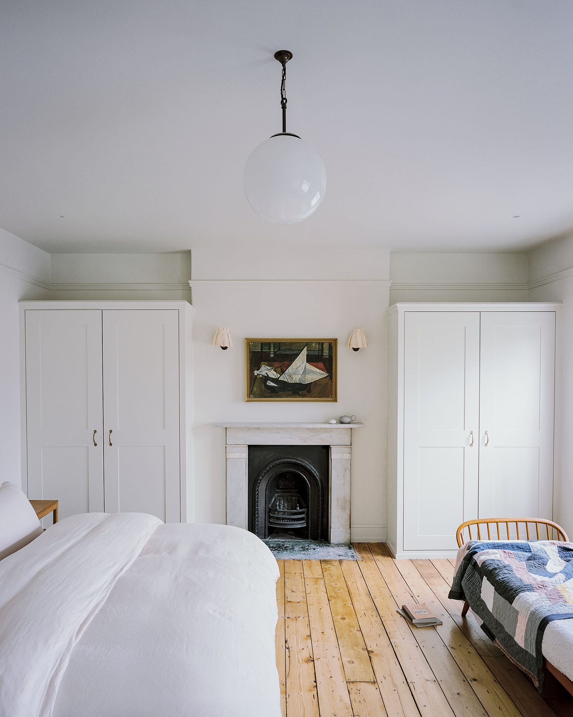 bedroom with victorian marble fireplace and original sanded wood floor, mid-century daybed