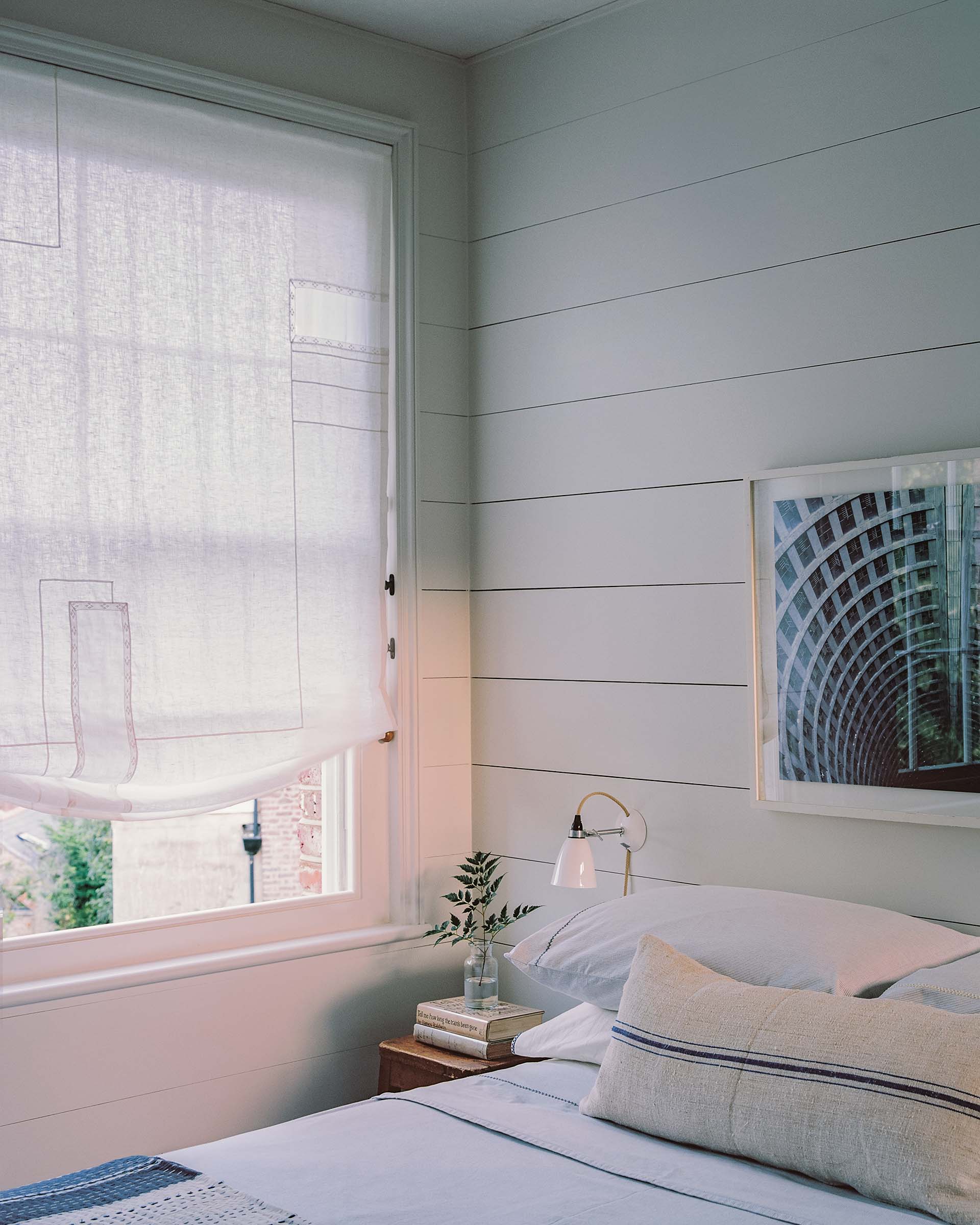 Georgian house designed by an architect in london, showing bedroom with wall panelling and sash window