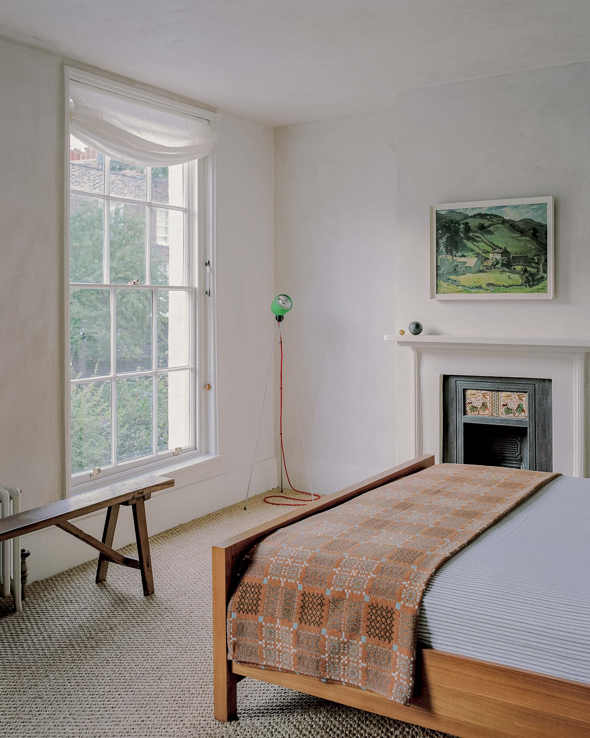 Hampstead georgian house bedroom: with original fireplace, sash window, sisal carpet, oil painting and lime plaster