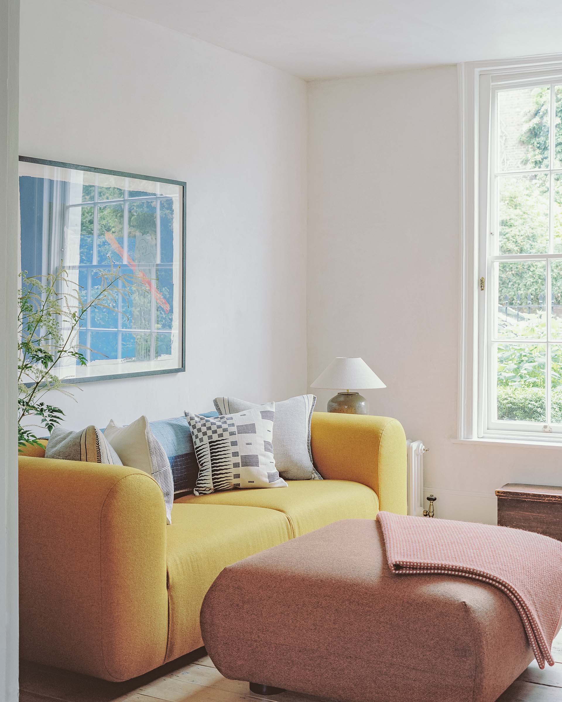 Hampstead georgian house renovation: living room with yellow sofa and art on lime plaster walls