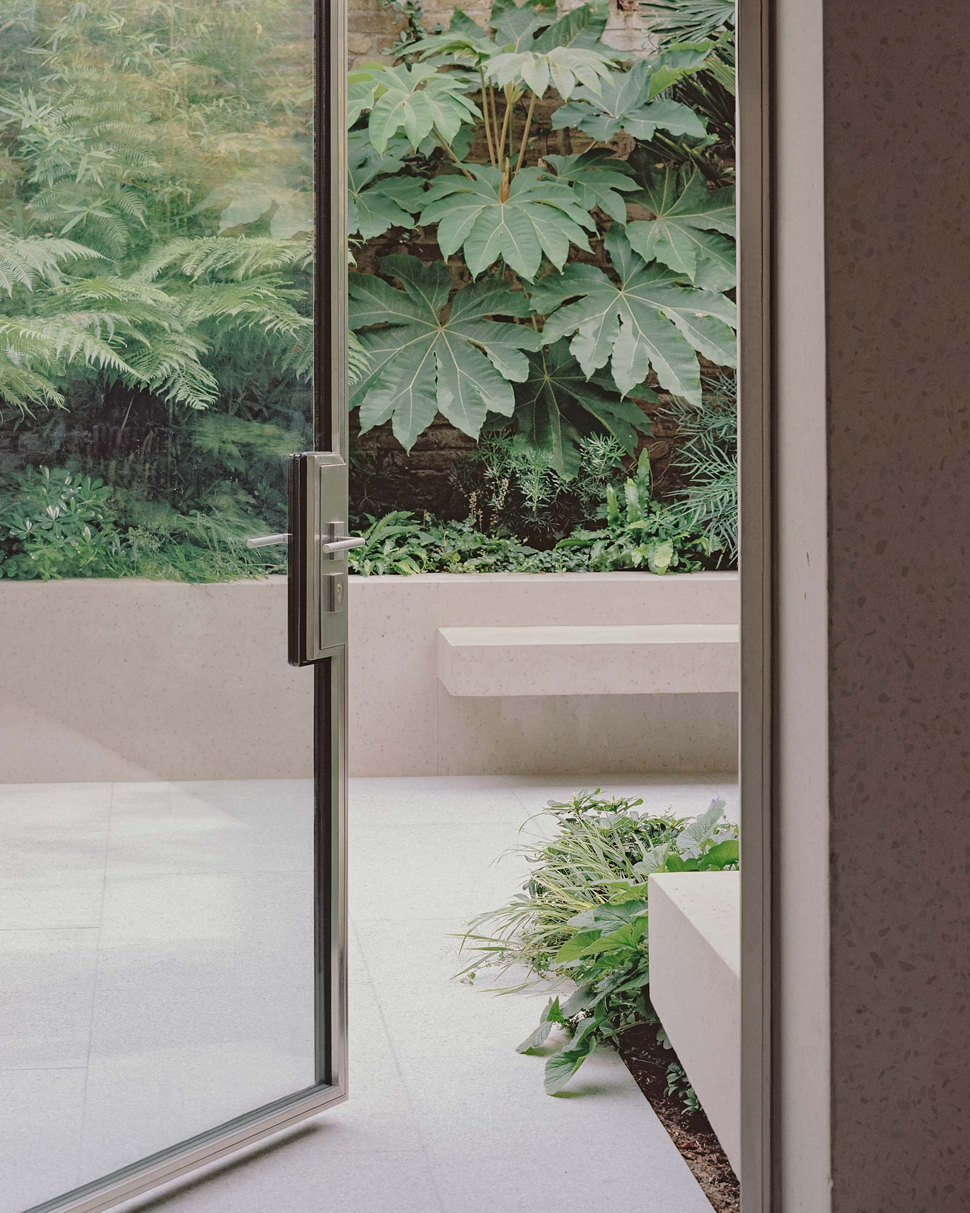 Hammersmith house extension garden design with metal door and terrazzo patio